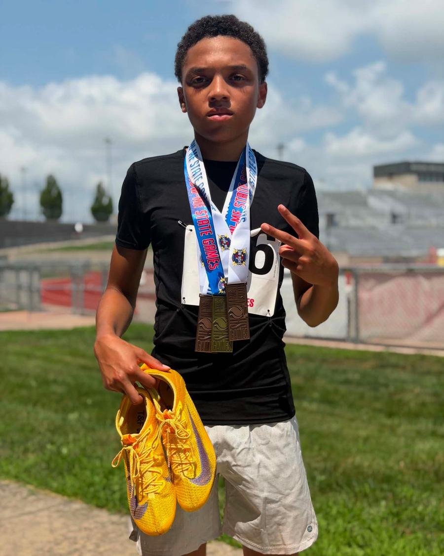 Track athlete wearing three Show-Me State Games medals