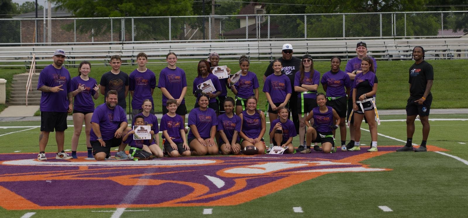 Flag football camp participants in purple BSP shirts holding certificates