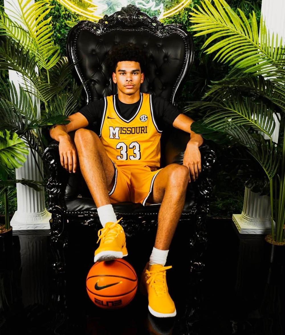 Basketball athlete in a gold jersey with a ball under his foot